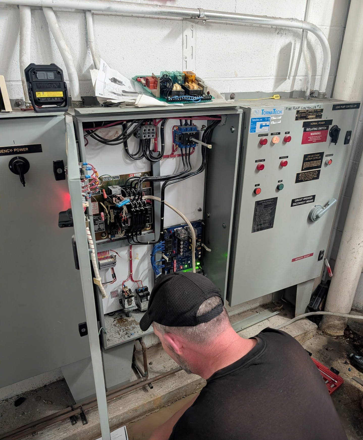 GenWorx technician reading fault codes at a generator control panel
