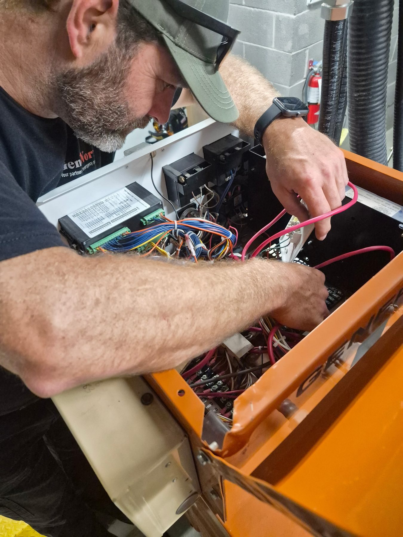 GenWorx technician diagnosing control wiring inside a standby generator