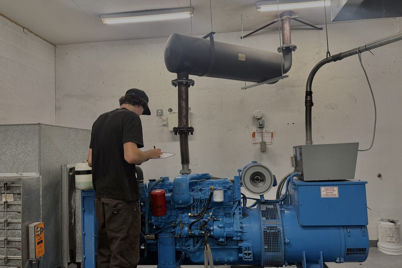 GenWorx technician recording readings during a standby generator service in Ontario